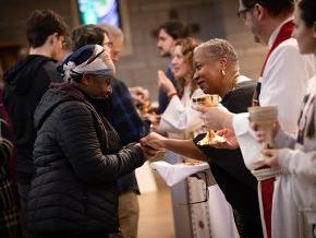 A line of seminary faculty greets and serves communion to a line of LR students and faculty in Grace Chapel